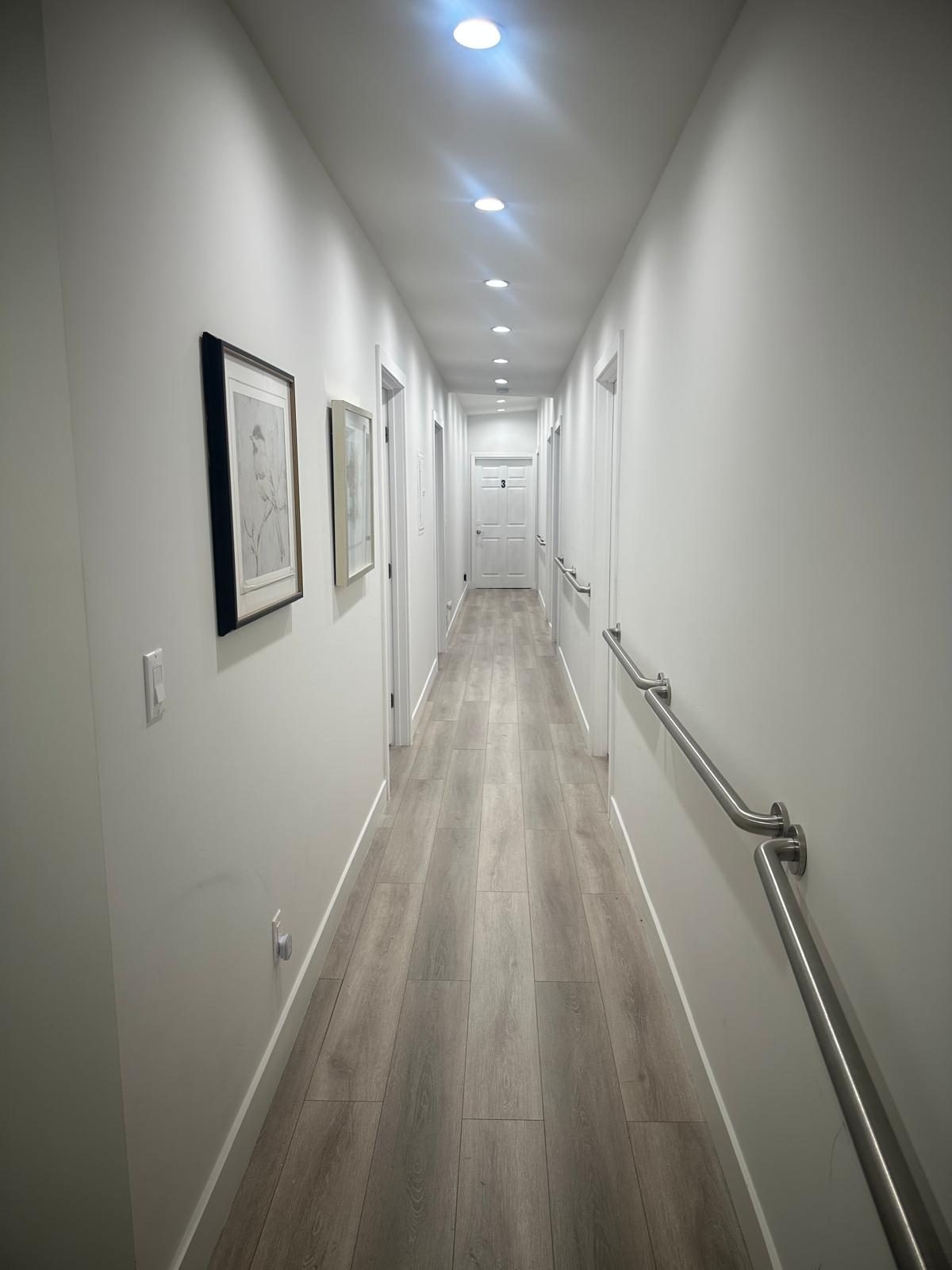 Hallway with grab bars at Allure Senior Living in Sunland