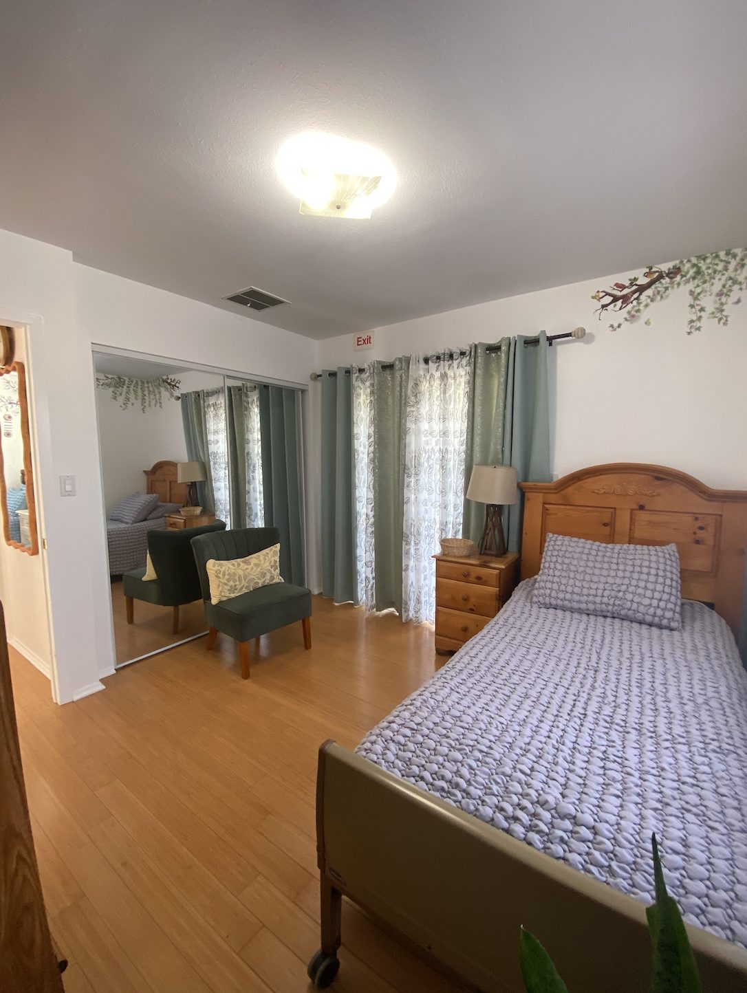 Private resident bedroom with sitting chair at Estar Board and Care in Northridge