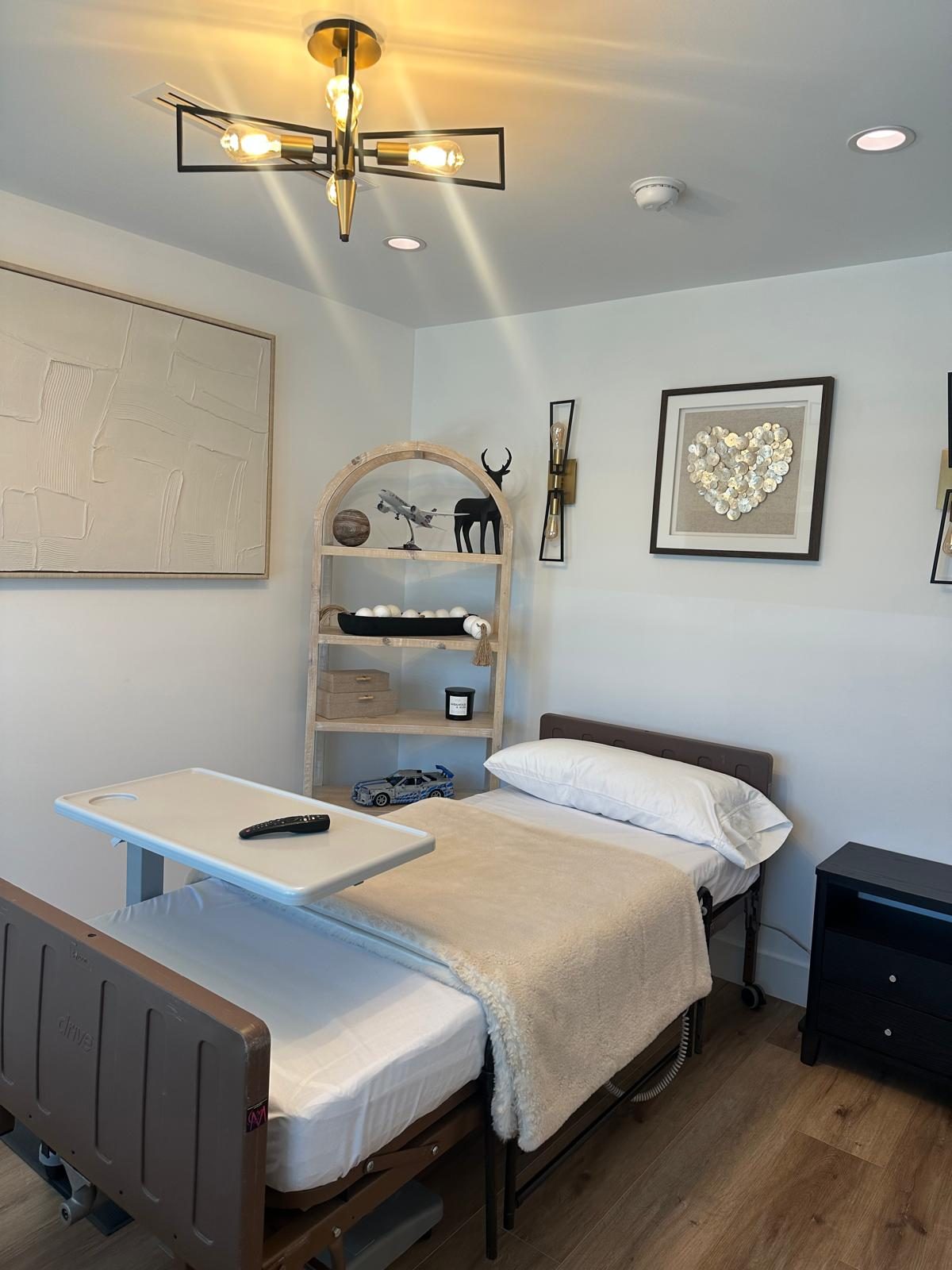 Resident bedroom with adjustable care bed and decorative shelving at Monogram Villa in Sherman Oaks